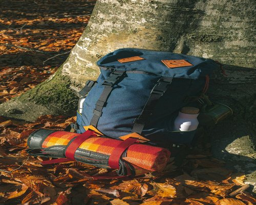 A well packed backpack showing layered clothing and a water bottle